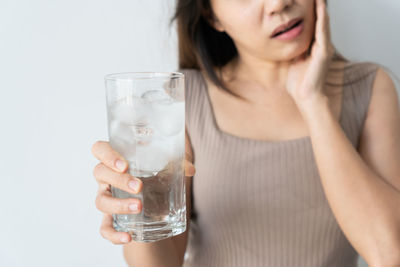 Midsection of woman drinking glass