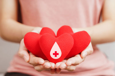 Close-up of woman holding heart shape with hands