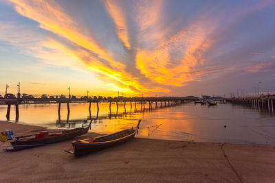 Boats moored in sea at sunset