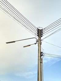 Low angle view of electricity pylon against sky