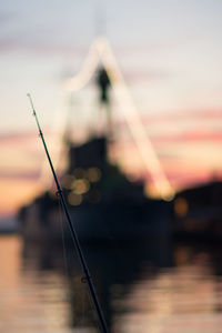 Close-up of fishing rod during sunset