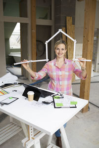 Young woman using laptop while sitting on table