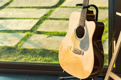 High angle view of guitar by glass window