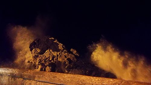 Firework display on rock at night