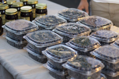 High angle view of blueberries in containers for sale at market stall