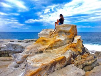 Rear view of man sitting on beach