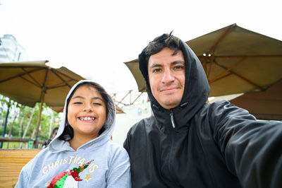 Portrait of young woman standing against sky