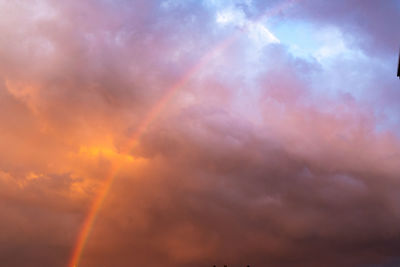 Low angle view of rainbow against sky during sunset