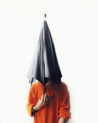 Rear view of man holding umbrella against white background