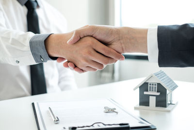 Midsection of man holding hands on table