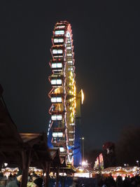 Low angle view of illuminated ferris wheel against sky at night