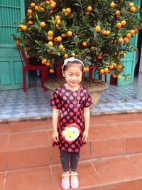 Portrait of girl standing by flowers