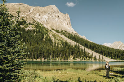 Man standing by lake against sky