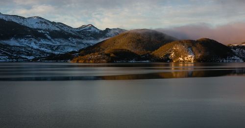Scenic view of lake and snowcapped mountains against sky