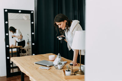 Woman looking at camera while standing on table