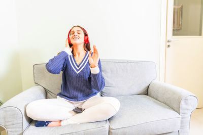 Woman sitting on sofa at home