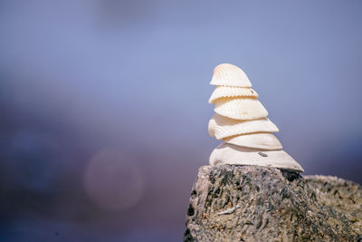 Close-up of stack of rocks against blue sky