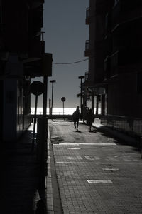 People walking on street amidst buildings in city