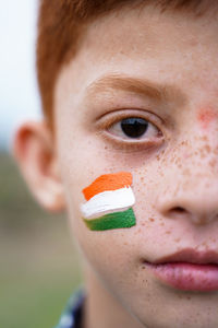 Close-up portrait of boy with indian flag face paint