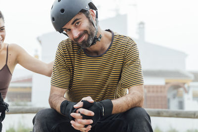 Full length portrait of young man sitting outdoors