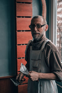 Portrait of man standing by window