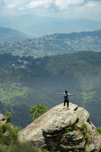 Man standing on rock looking at mountain