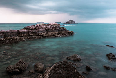 Rocks in sea against sky