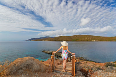 Woman looking at sea against sky