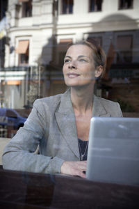 Businesswoman sitting in cafe and using laptop