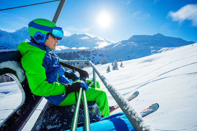 Rear view of man standing on snow covered mountain