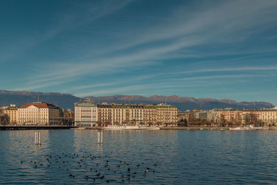 Buildings by sea against sky in city