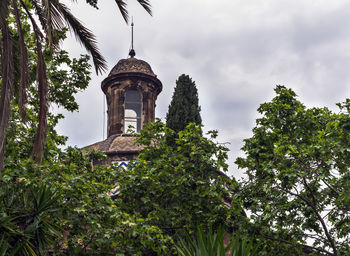 Low angle view of trees and building against sky