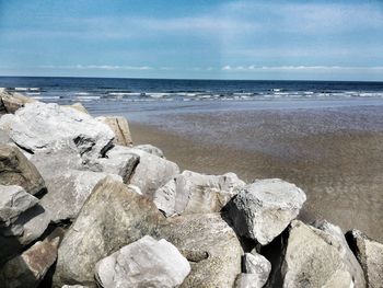 Scenic view of rocks on beach against sky