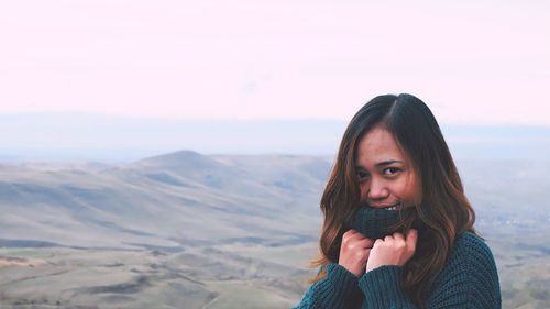 Beautiful woman standing on mountain against sky