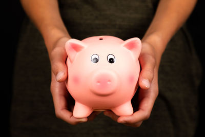 Close-up of woman hands holding piggy bank