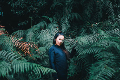 Portrait of young woman with tree in winter