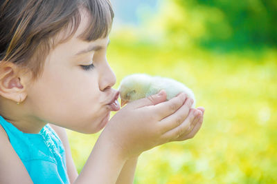 Close-up of girl blowing bubbles on field