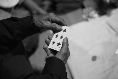 Midsection of man playing cards at table