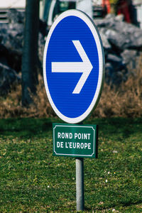 Close-up of road sign on field