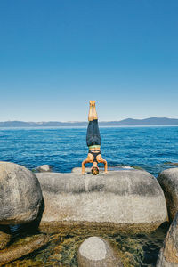 Young woman practicing yoga on lake tahoe in northern california.
