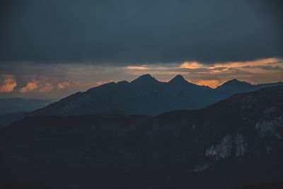 Scenic view of mountains against cloudy sky