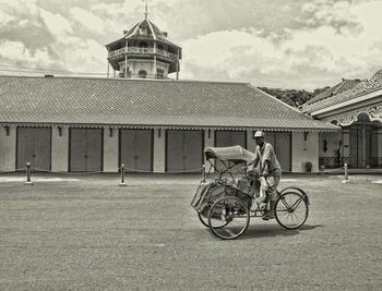 Man with bicycle against sky