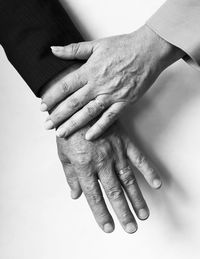 Cropped image of senior couple hands on table