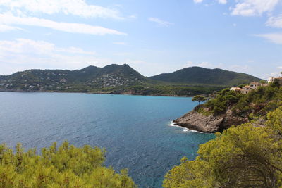 Scenic view of sea and mountains against sky