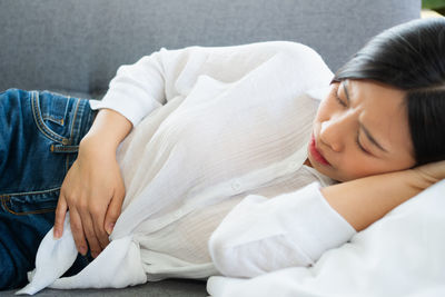 Midsection of woman lying on bed