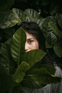 Close-up portrait of young woman amidst leaves