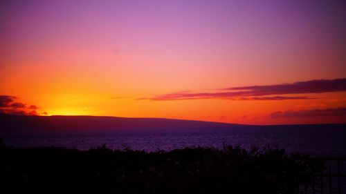 Scenic view of sea against dramatic sky during sunset