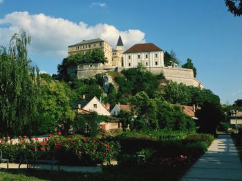 Low angle view of castle and trees against sky on sunny day