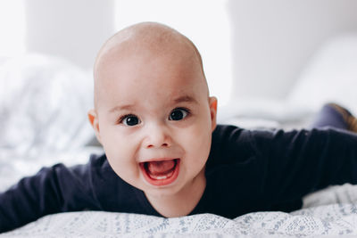 Portrait of cute baby lying on bed