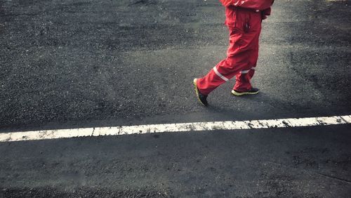 Low section of manual worker walking on road